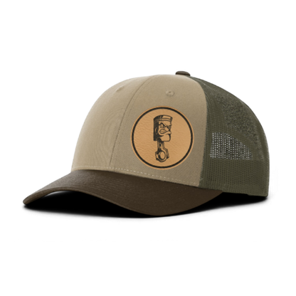 Trucker hat with angry piston patch, tan front and dark olive mesh back panels.