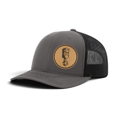 Gray trucker cap with circular piston patch and black textured mesh side