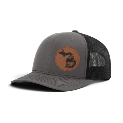 Charcoal gray trucker hat with circular fish patch; dark mesh side panels