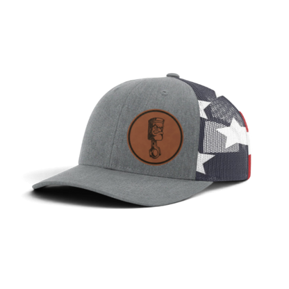 Gray trucker cap with circular piston patch and black mesh with star pattern