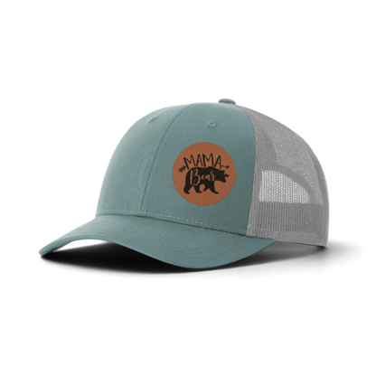 Teal trucker hat with white mesh and brown “MAMA Bear” patch.