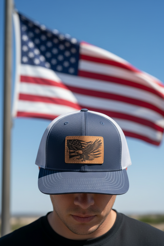 American Flag with Eagle leatherette patch trucker hat worn by model outdoors with patriotic eagle and flag backdrop – Keeko Designs