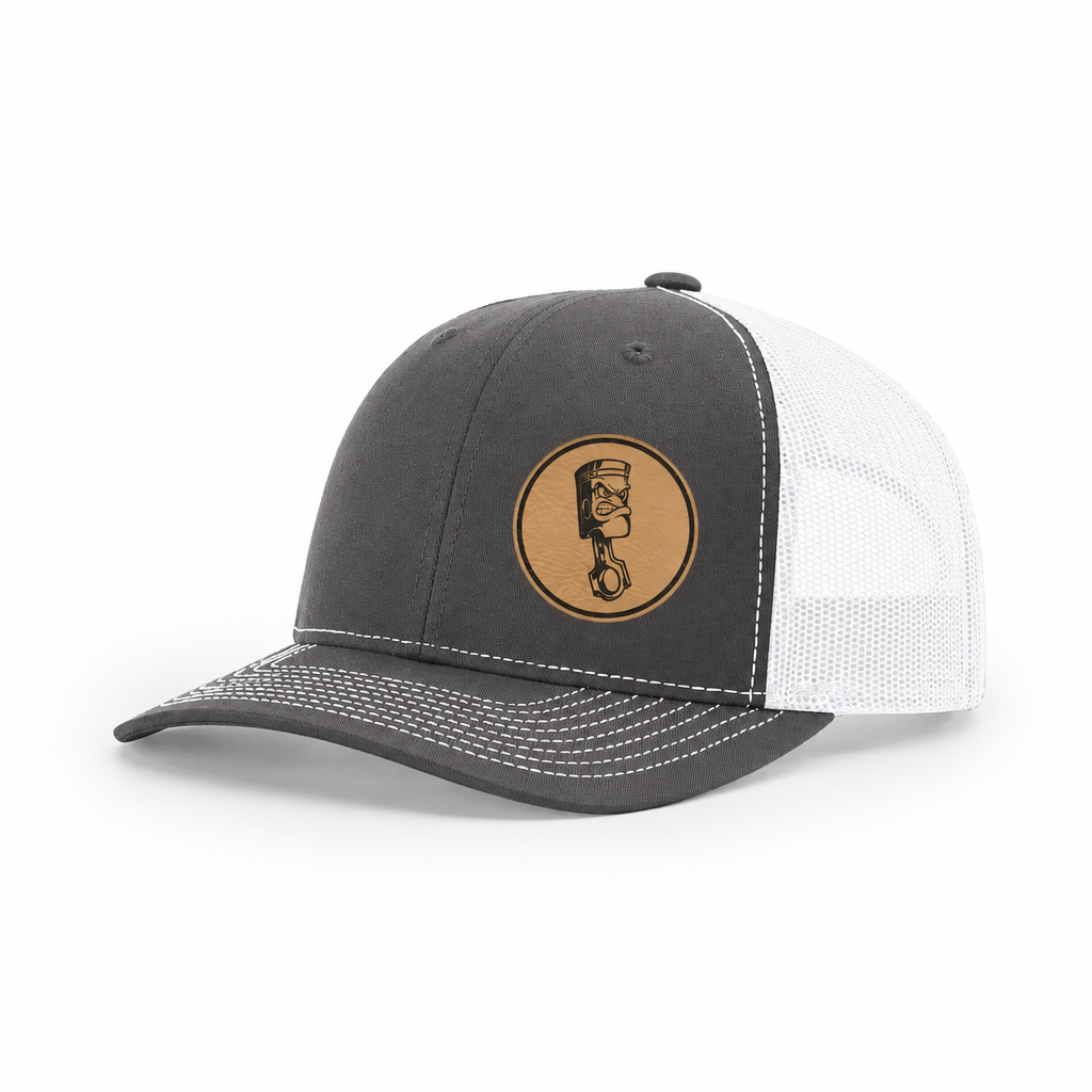 Gray trucker hat with white mesh back and round angry piston patch on front.
