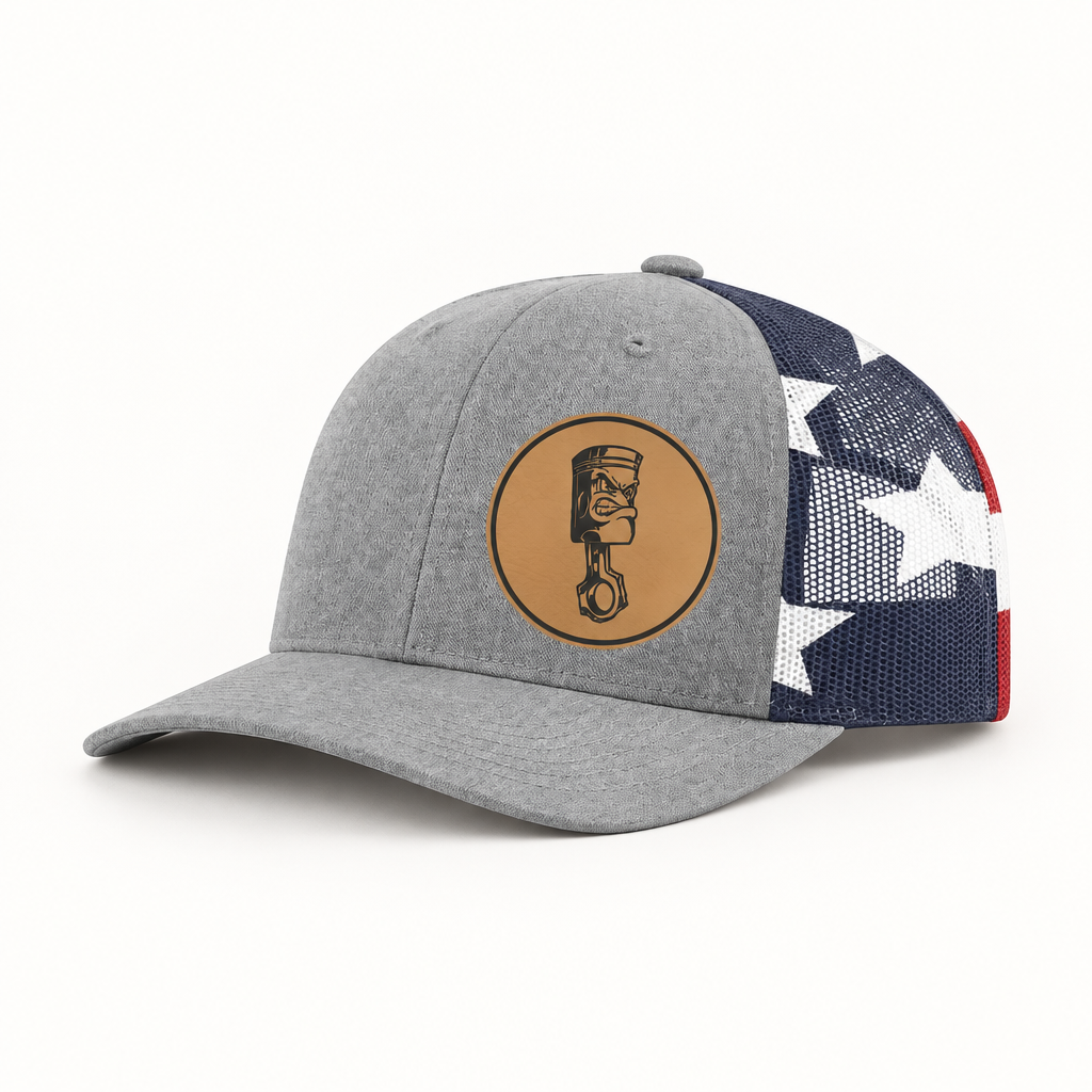 Light gray trucker hat with navy/white/red star mesh side and round angry piston patch.