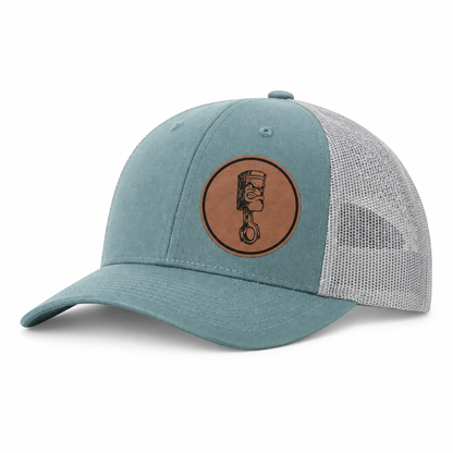 Teal canvas trucker hat with gray mesh back, centered Angry Piston patch