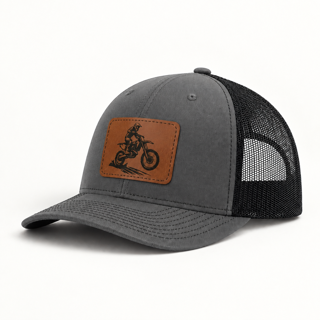 Dark gray trucker hat with brown dirt bike patch and black mesh side panels