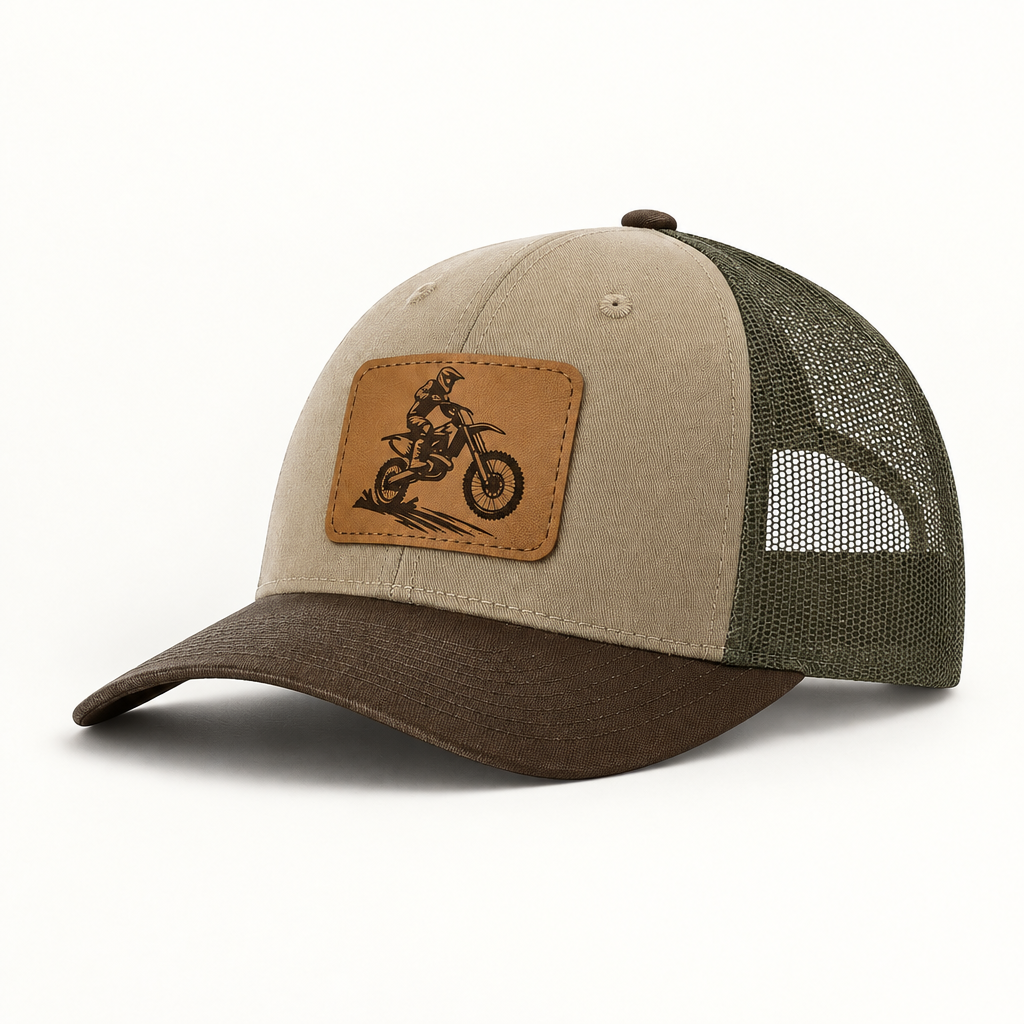 Trucker hat in tan with olive mesh; brown leather patch with dirt bike rider graphic.