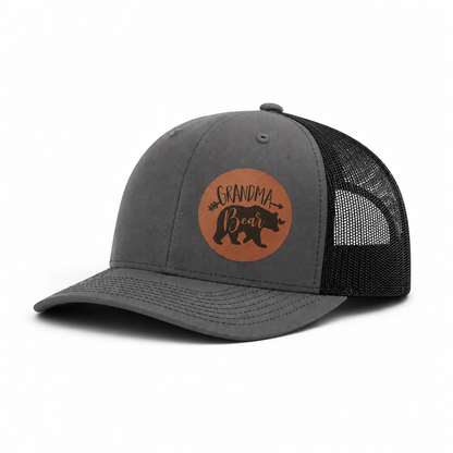 Dark gray trucker hat with Grandma Bear round patch and black mesh side panels