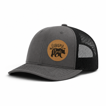 Dark gray trucker hat with Grandma Bear round patch and black mesh side panels