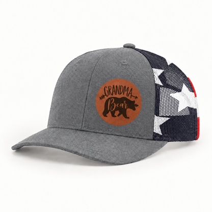 Gray trucker hat with Grandma Bear round patch and navy/white mesh side panels