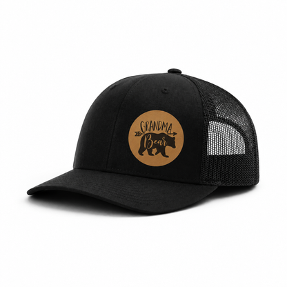 Black trucker hat with black mesh sides and brown Grandma Bear patch.