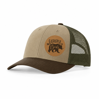 Tan and dark green trucker hat with brown Grandma Bear patch and mesh panels.