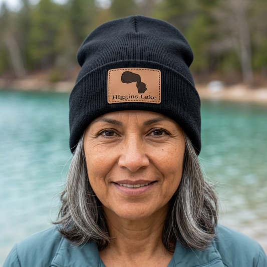 Dark beanie hat with leather patch showing Higgins Lake logo