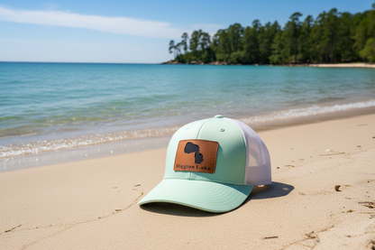 Mint and white trucker hat with tan leather Higgins Lake patch