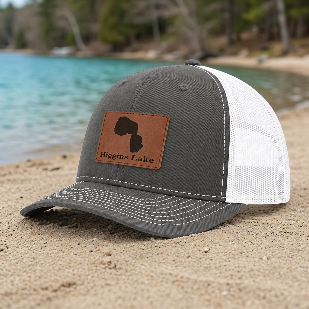 Charcoal trucker hat with white mesh panels and Higgins Lake tan front patch