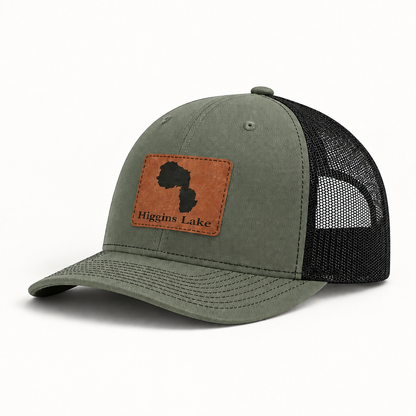Trucker hat with tan patch, sage-green front and black mesh back, curved brim