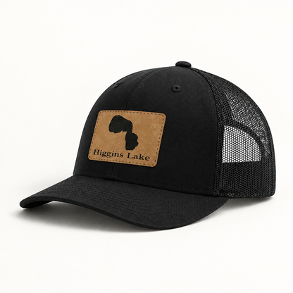 Black trucker hat with black mesh back and tan square patch on the front
