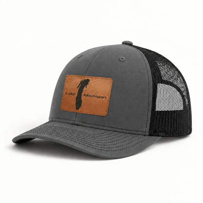 Dark gray trucker hat with black mesh back and rectangular Lake Michigan patch, brim