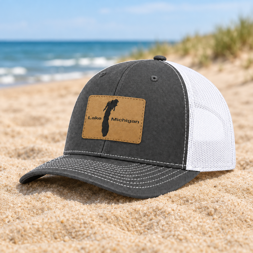 Dark gray and white trucker hat with tan patch showing Lake Michigan map.