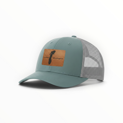 Teal trucker hat with tan patch and gray mesh back, clean low-profile look