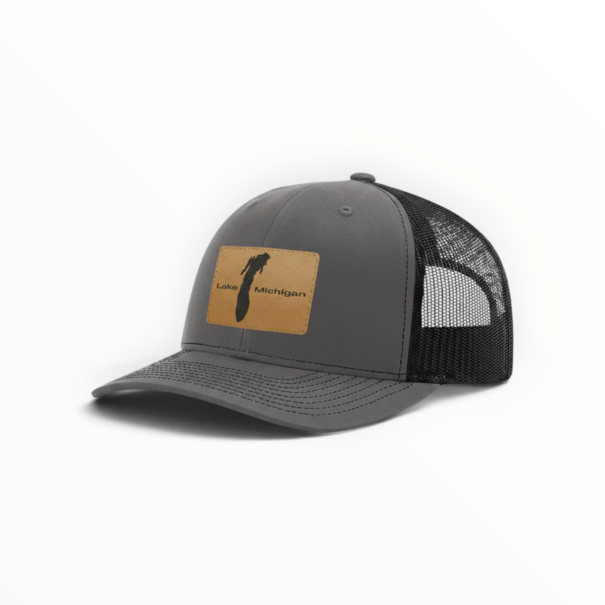 Charcoal trucker hat with tan patch and black mesh back, curved brim