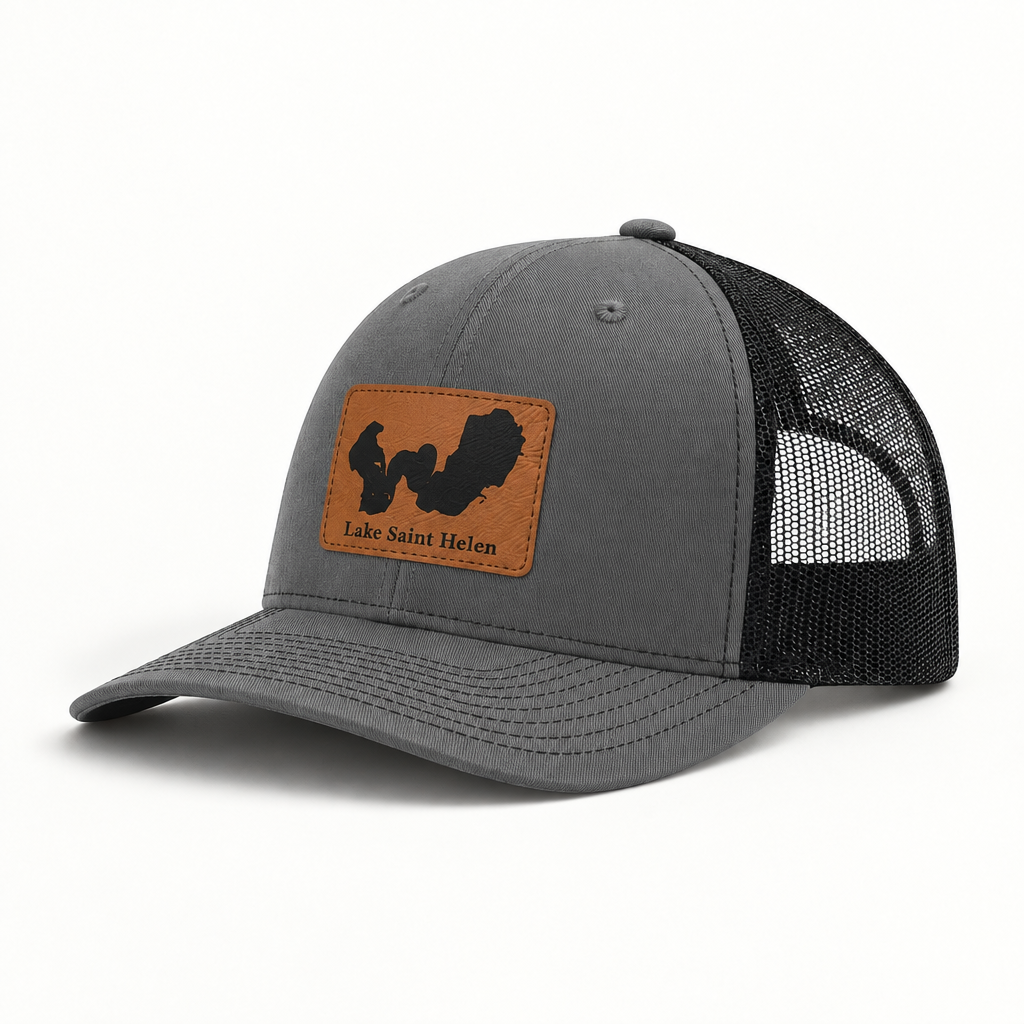 Heather gray trucker hat with tan logo patch, black mesh back, curved brim, snap button