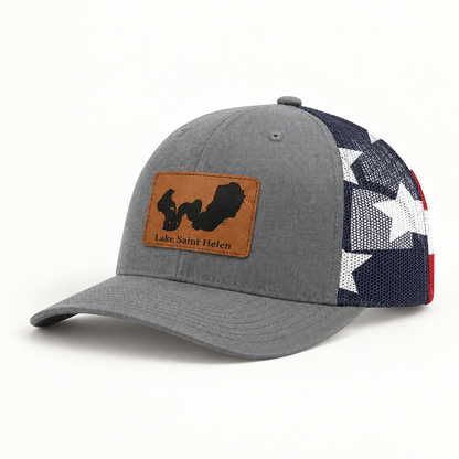 Dark navy trucker hat with tan logo patch, black mesh back, star-pattern side panel