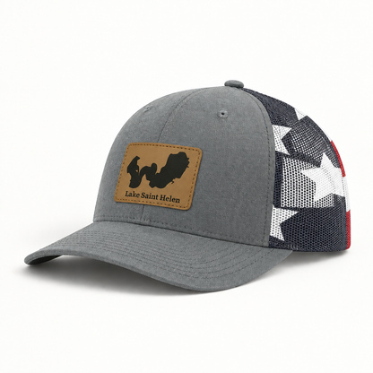 Gray trucker hat with tan logo patch, black mesh back, curved brim, snap button