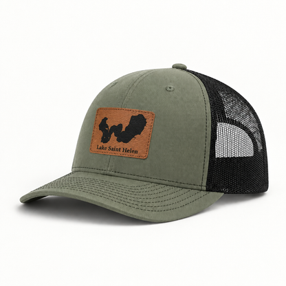Olive green trucker hat with tan logo patch, black mesh back, curved brim, snap button