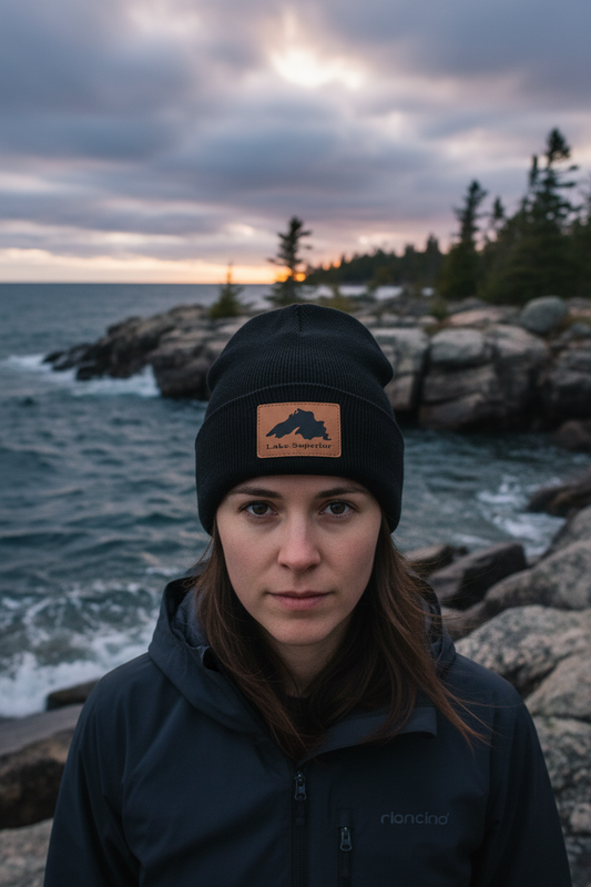 Lake Superior leatherette patch beanie close-up lifestyle shot on rugged Great Lakes shoreline – Keeko Designs