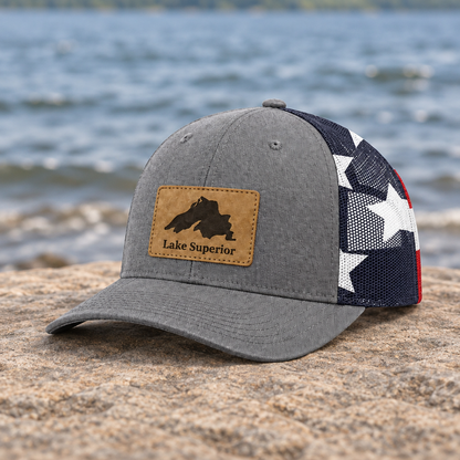 Gray trucker cap with leather patch, star-pattern mesh back and red accents