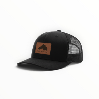 Black trucker hat with front patch, Lake Superior silhouette, and mesh back