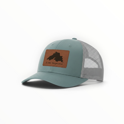 Teal trucker hat with gray mesh and tan Lake Superior patch.