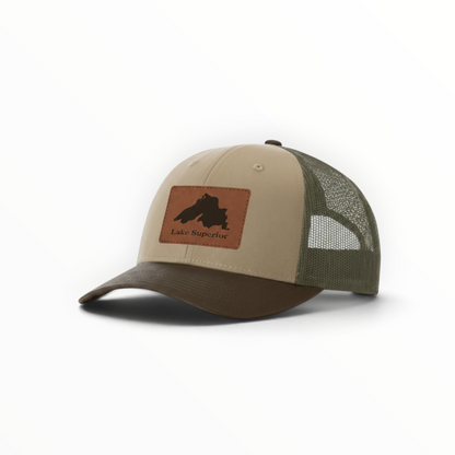Two-tone trucker hat in tan and dark green with Lake Superior patch and curved brim