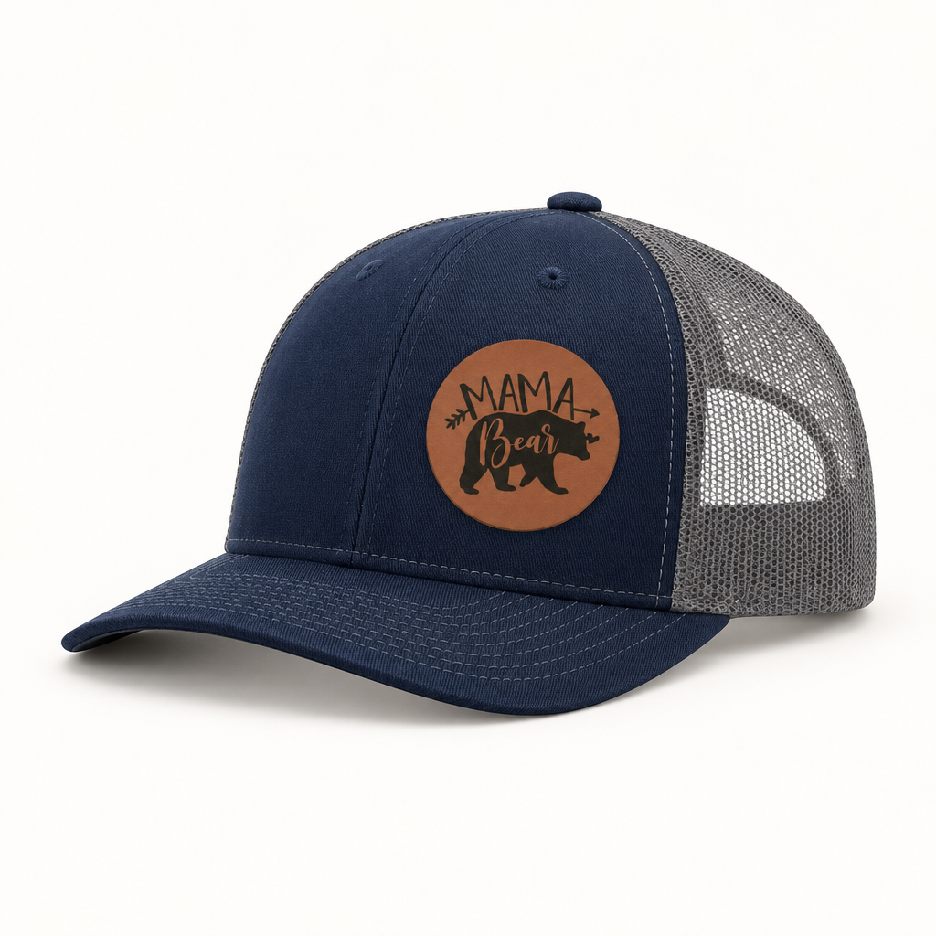 Navy front trucker hat with gray mesh back and tan “Mama Bear” patch.