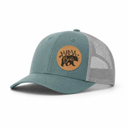 Teal front trucker hat with tan “Mama Bear” patch and gray mesh back.