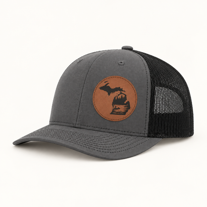 Gray trucker hat with tan fishing patch and black mesh side panels