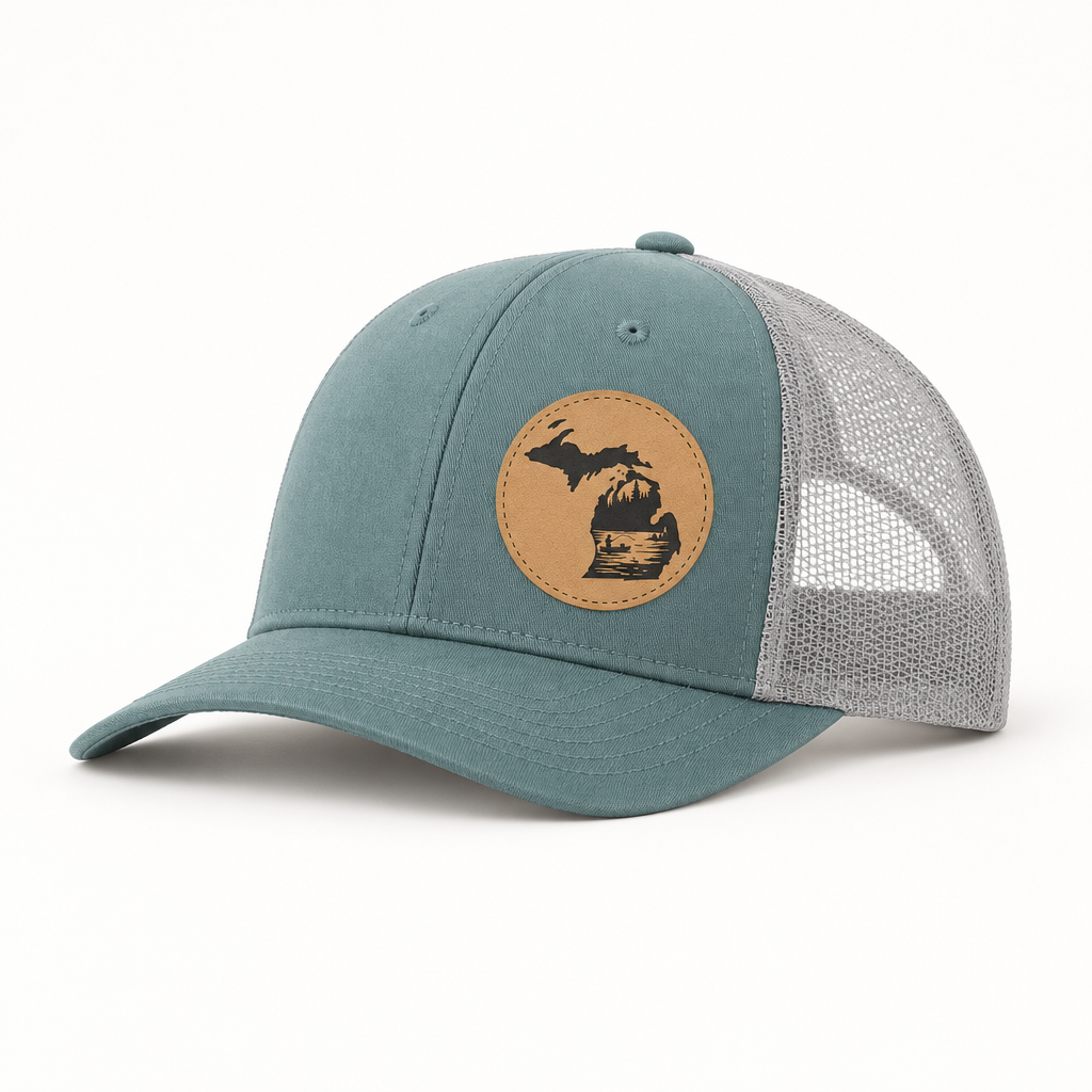 Teal trucker hat with tan patch featuring a fishing river landscape, mesh back