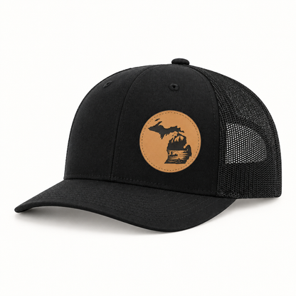Black trucker hat with tan fishing patch and black mesh back, curved brim