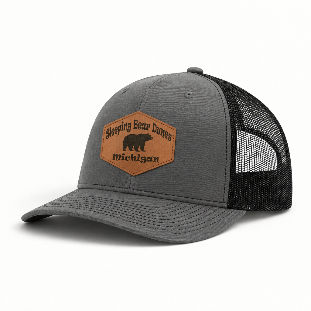 Gray trucker hat with black mesh sides and tan patch reading Sleeping Bear Dunes Michigan