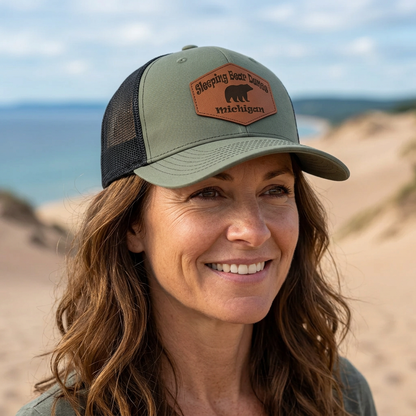Green trucker hat worn by model, Sleeping Bear Dunes Michigan patch on front