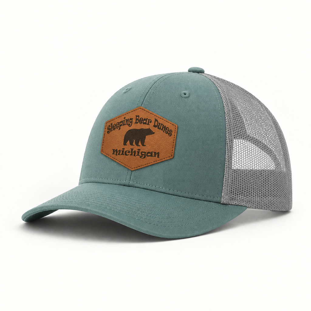 Teal trucker hat with gray mesh sides and brown patch reading Sleeping Bear Dunes Michigan