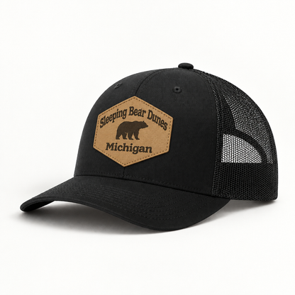 Black trucker hat with black mesh back; front patch says 'Sleeping Bear Dunes Michigan'