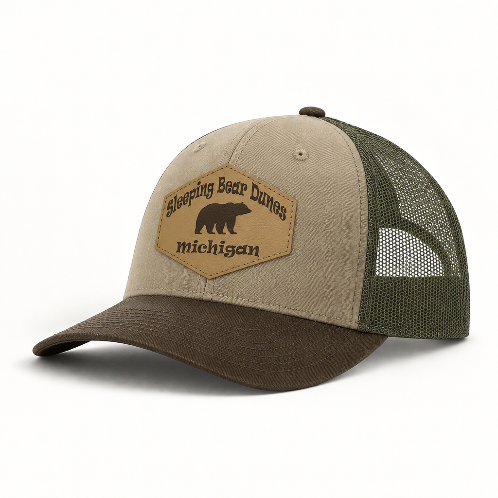 Tan trucker hat with green mesh back; front patch says 'Sleeping Bear Dunes Michigan'